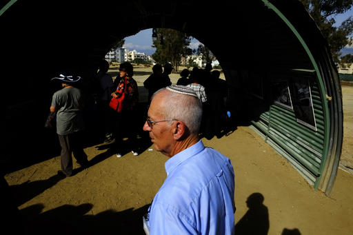 A Jewish man stands in front of a recreation of a semi-circular, corrugated iron hut that housed detainees, at the Cypriot military camp in capital Nicosia, on Wednesday, Nov. 9, 2016. Dozens of people born to Jewish refugees interned in Cyprus after World War II have marked the 70th anniversary of the start of such detentions at a ceremony on the east Mediterranean island. A memorial commemorating the event was unveiled at a Cypriot army camp that formerly housed a British military hospital where hundreds of Jewish infants were born. (AP Photo/Petros Karadjias)