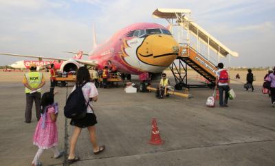epa05108304 Picture made available 18 January 2016 of airline passengers as they pass the splattered bird like nose of a Nok Air (Nok meaning bird in Thai language) aircraft, at Udon Thani Airport, north-east Thailand, about 600km from Bangkok, 17 January 2016. Airports in Thailand are catering for more and more passengers, as budget travel and more routes open the doors for increasing consumer demand for flights. Some airports face over capacity and airlines across the world are under scrutiny with the release of international comparisons of air carrier safety ratings.  EPA/BARBARA WALTON