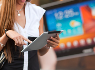 Young Woman with tablet computer walking on street