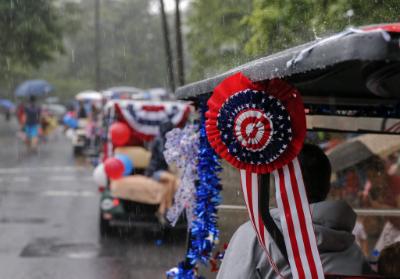 epa04831229 People brave heavy rain to participate in the Avondale Estates 4th of July Parade to celebrate the US Independence Day holiday in Avondale Estates, Georgia, USA, 04 July 2015.  EPA/ERIK S. LESSER
