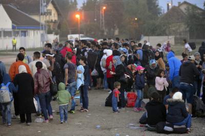 epa04929667 Migrants wait for a bus at a temporary resting point at the market square in Magyarkanizsa, Serbia, 14 September 2015. Hungary registered more than 10,000 migrants after they crossed from Serbia over the weekend, police data showed, a day before the country was set to seal its border to new arrivals.  EPA/EDVARD MOLNAR HUNGARY OUT