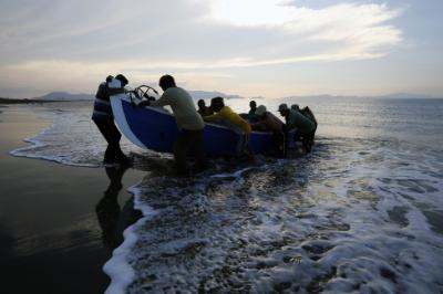 epa04661755 A group of fishermen push their boat ashore after returning from a catch at a beach near the fishing area of Kampung Jawa Village, Aceh province, Indonesia, 14 March 2015. Indonesian waters that reach more than 5.8 million kilometers square makes Indonesia one of the biggest contributors of fishery products in South Asia.  EPA/HOTLI SIMANJUNTAK